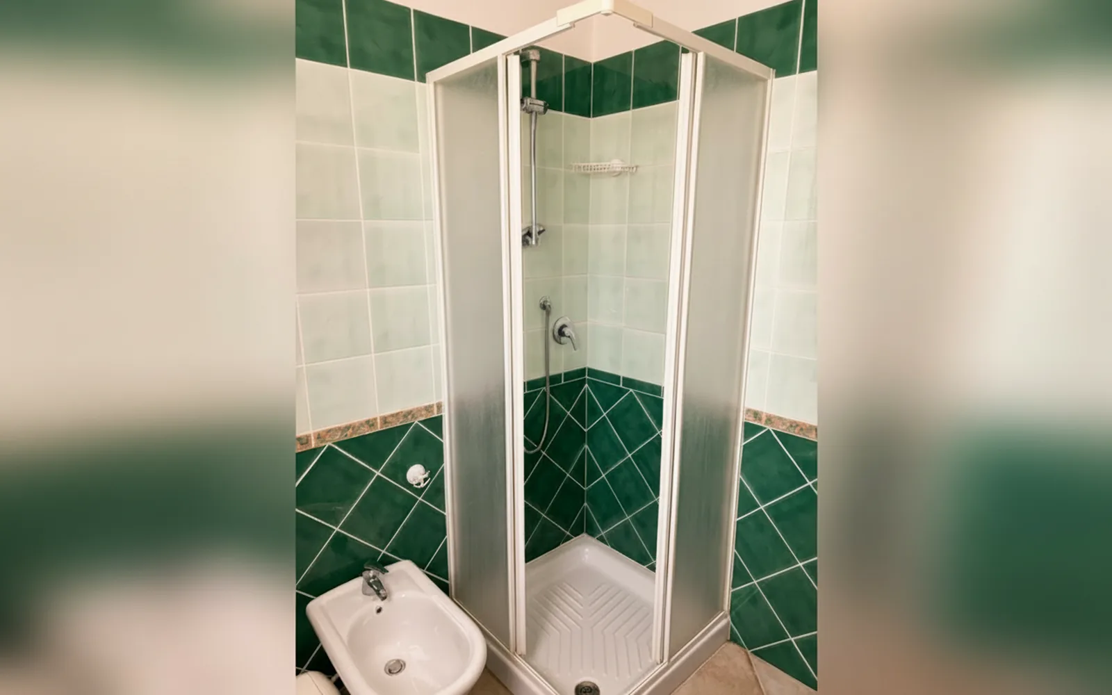 Il bagno con box doccia e rivestimento verde